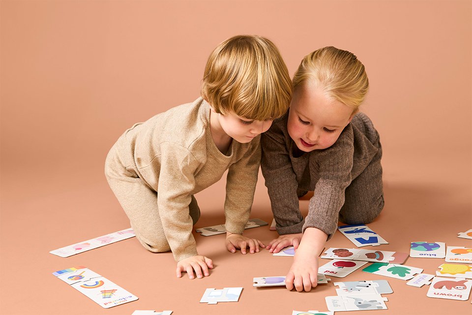 Two toddlers playing a Chad Valley puzzle game.